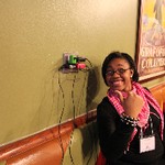 Student smiling and pointing at for cell phone chargers